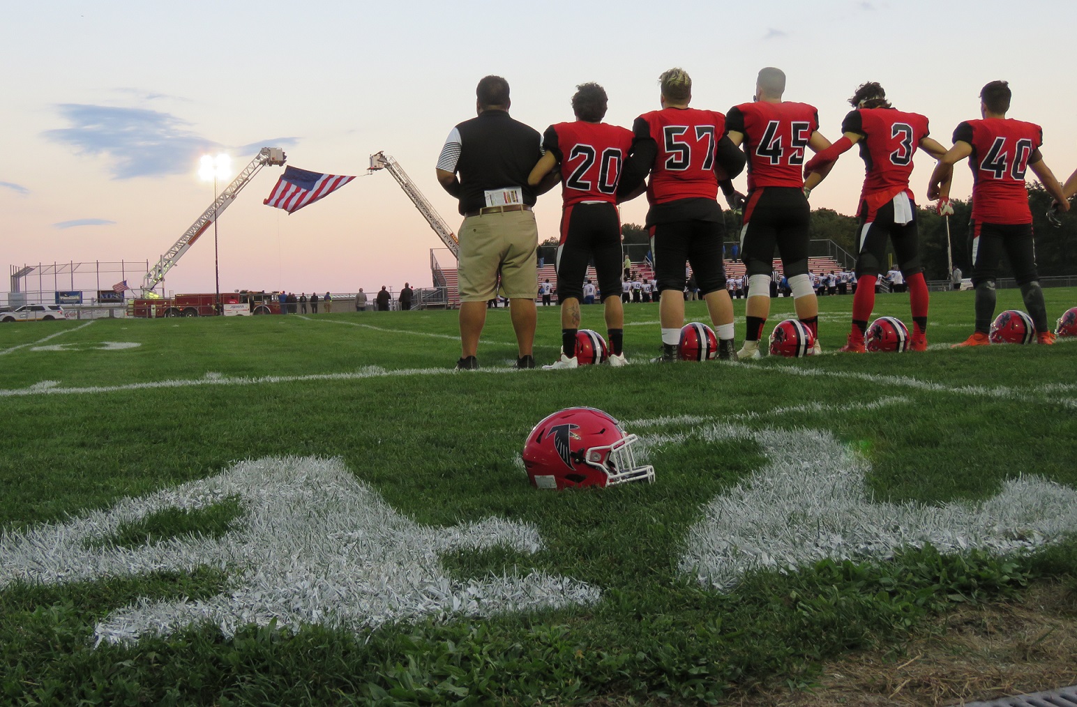In front of the painted No. 42 for Michael Ziegler and standing facing the American flag, the Niagara-Wheatfield Falcons listen to the national anthem before its homecoming victory over Kenmore West, 28-21. (Photo by David Yarger)